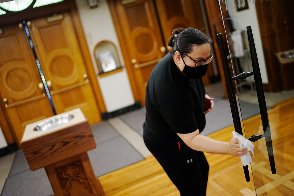 Vanessa Velez disinfects high touch surfaces after Mass
